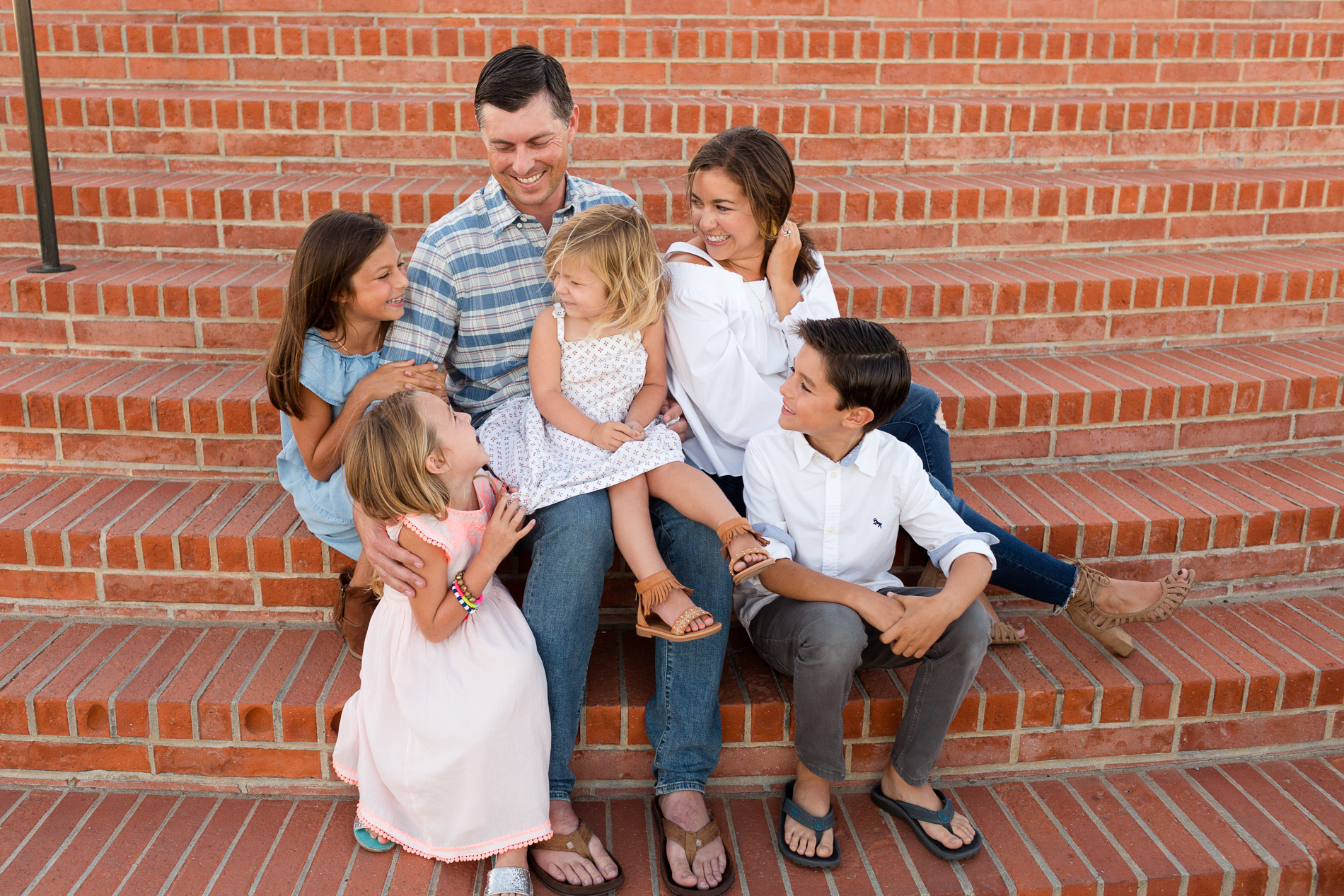 a family sits on a set of brick steps together at San Diego's mt solidad