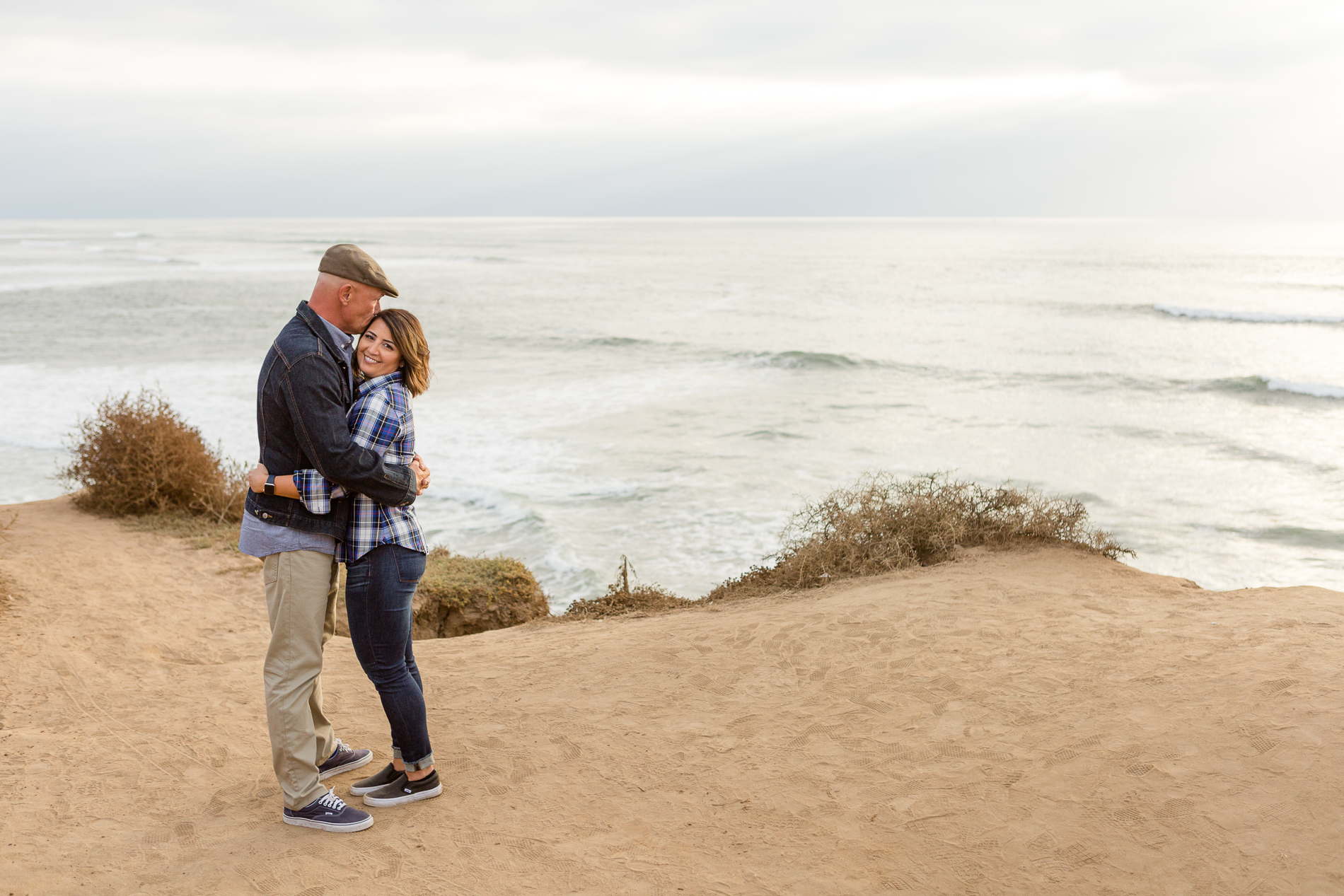 couple hugging at sunset cliffs San Diego