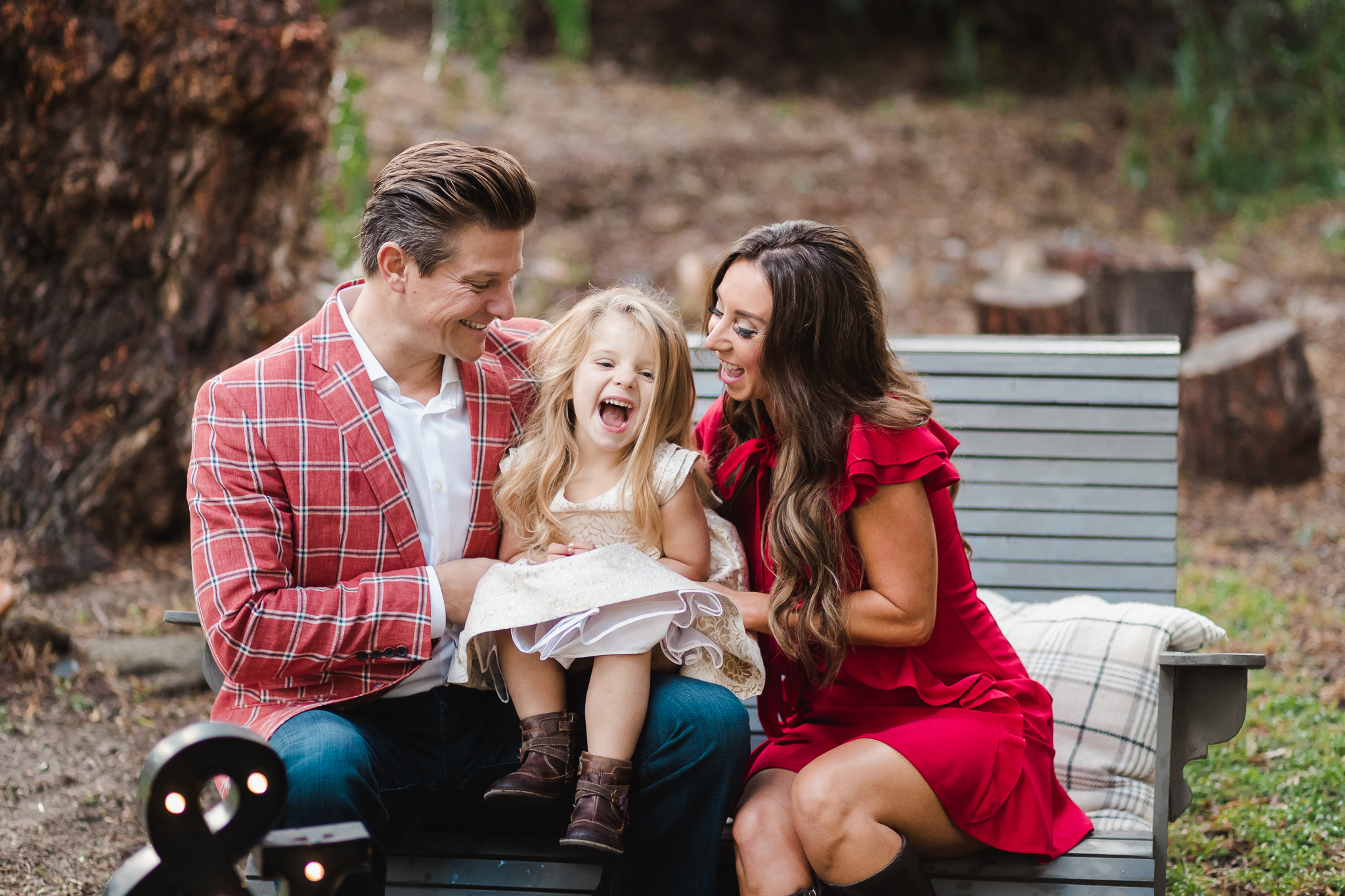 a family laughs together dressed in holiday attire