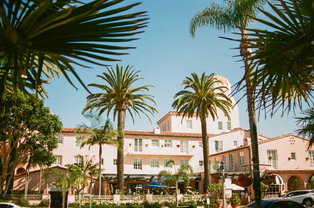Photo of building surrounded by palm trees in the sun