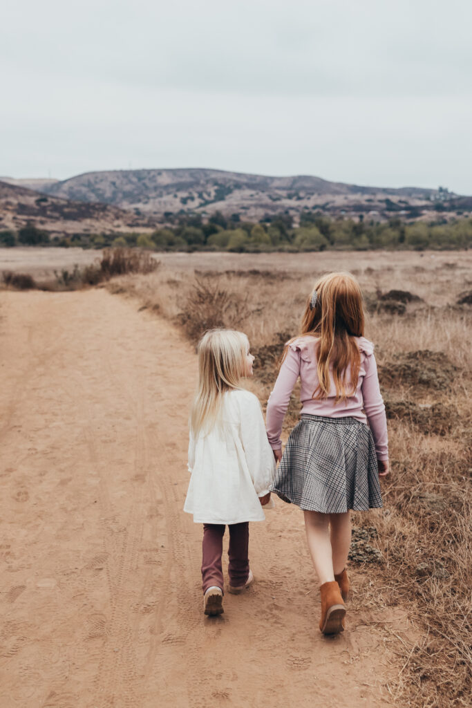 Sisters walking down San Diego trail during family activity