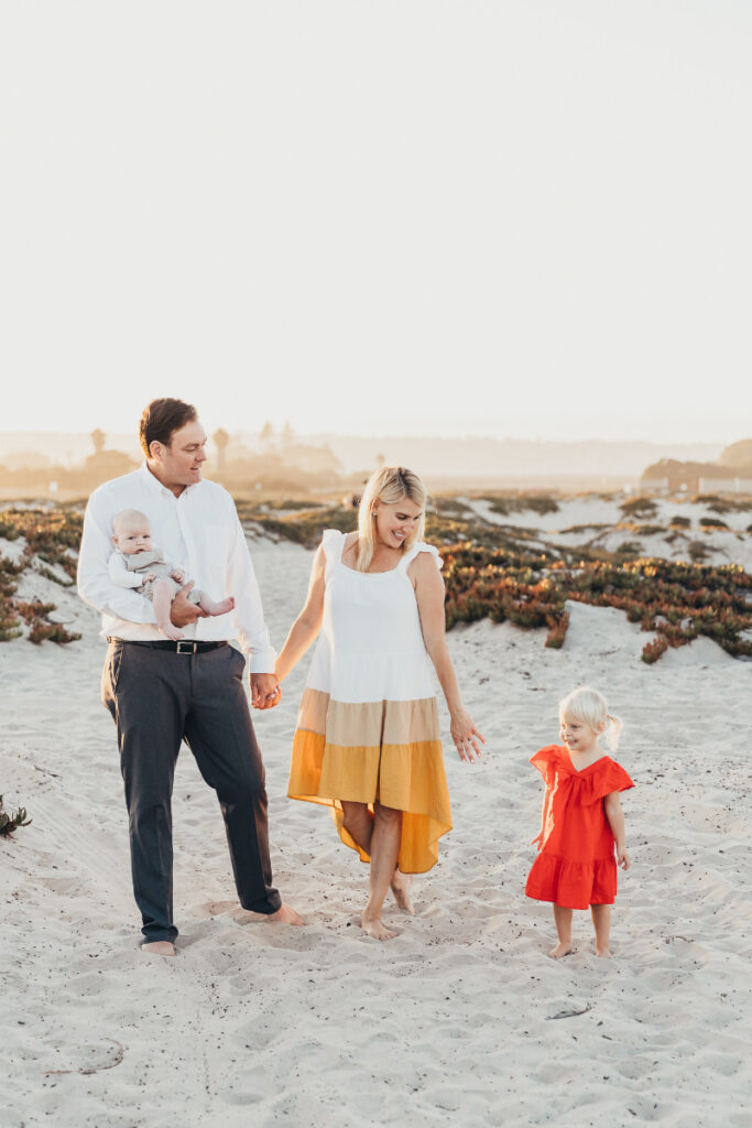 Family walking together on sand dunes at one of the best beaches in San Diego, soft light moment