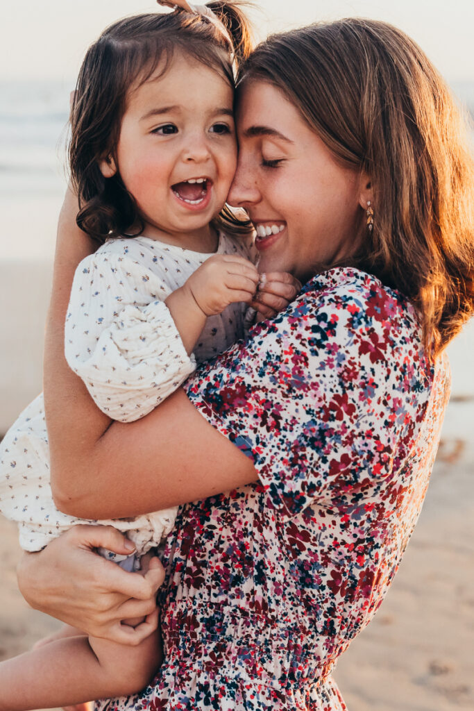 Mother holding and laughing with young child, warm candid moment full of connection and love